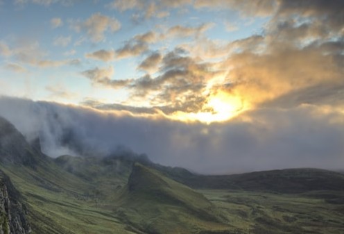 Fog filling a forest valley between mountain ridges at dawn
